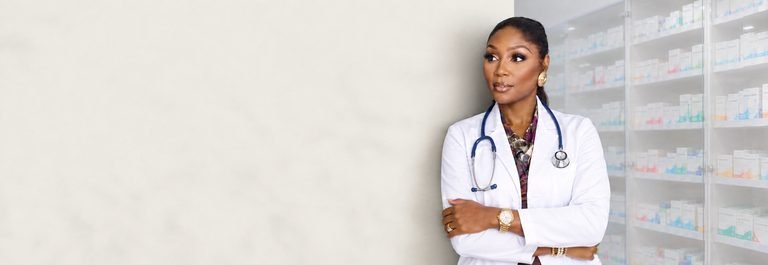 The CEO in a white coat and stethoscope beside well-stocked pharmacy shelves